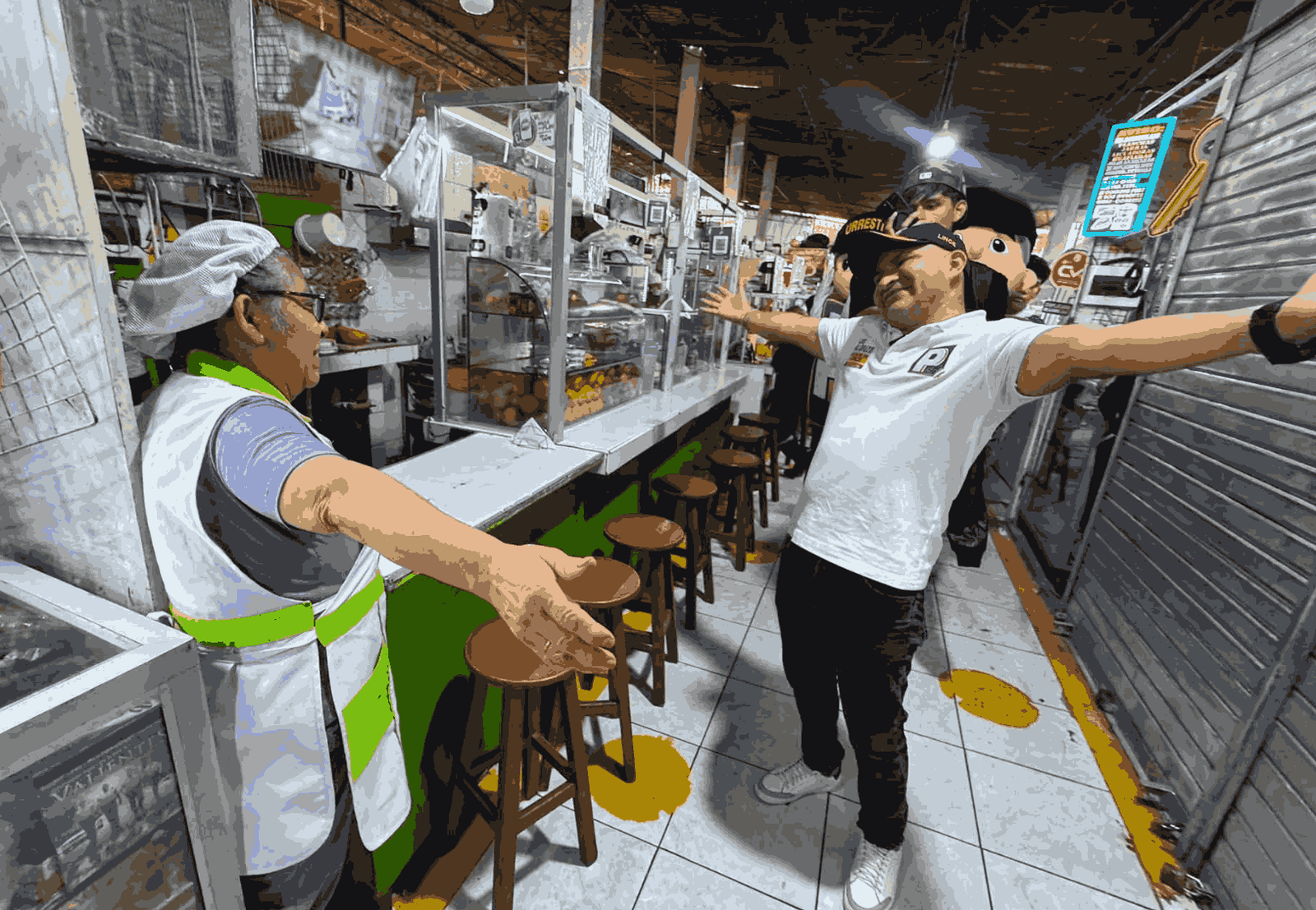 Luis Alonzo compartiendo un momento cercano con una trabajadora durante su visita al Mercado 10 de Junio en Lince